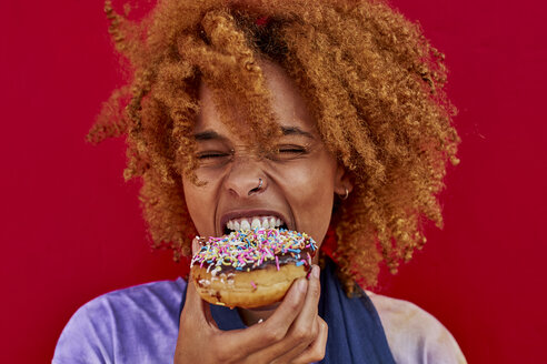 Portrait of woman eating a donut - VEGF00285