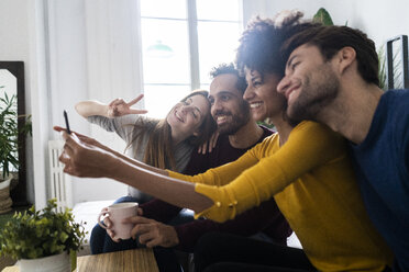 Four happy friends sitting on couch taking a selfie - GIOF06441