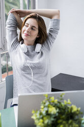 Young woman stting at table at home with laptop - GIOF06454