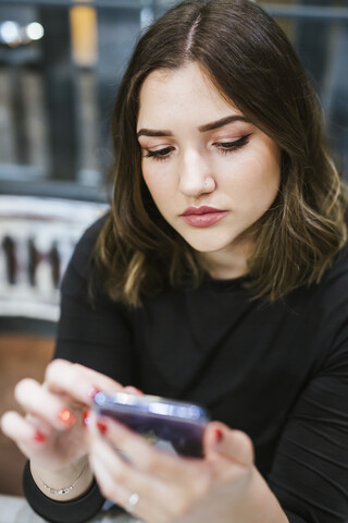 Porträt einer jungen Frau, die ein Mobiltelefon benutzt, lizenzfreies Stockfoto
