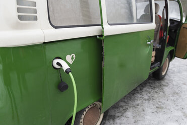 Elektro-Lieferwagen wird in der Winterlandschaft aufgeladen, Kuopio, Finnland - PSIF00286