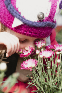 Nahaufnahme eines an Blumen riechenden Mädchens - PSIF00295