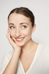 Portrait of smiling young woman with head in hand - PNEF01531