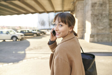 Portrait of young businesswoman on the phone outdoors - PNEF01561