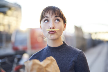 Porträt einer jungen Frau mit Pommes frites-Schnurrbart und schmollendem Mund - PNEF01566