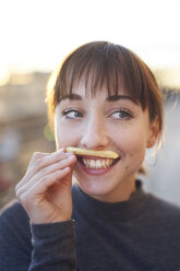 Porträt einer lachenden jungen Frau mit Pommes frites-Schnurrbart - PNEF01567