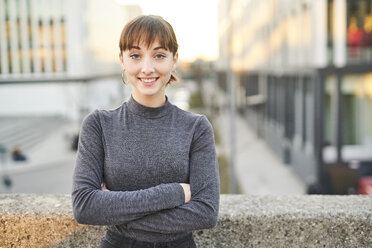 Portrait of smiling young woman with arms crossed - PNEF01571