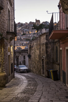 Blick aus einer Gasse in Ragusa Ibla auf Ragusa Superiore in der Abenddämmerung, Ragusa, Sizilien, Italien - MAMF00763