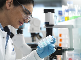 Biotech Research, Scientist viewing samples in multi well plate ready for analysis during a experiment in the laboratory - ABRF00407