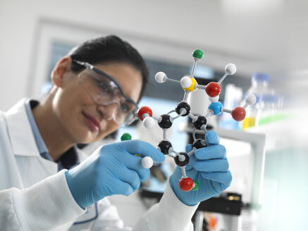 Biotech-Forschung, Wissenschaftler, der während eines Experiments ein molekulares Kugel-Stab-Modell einer chemischen Formel untersucht - ABRF00410