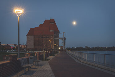 Waterfront promenade with okd warehouse at night, Wittenberge, Brandenburg, Germany - KEBF01228