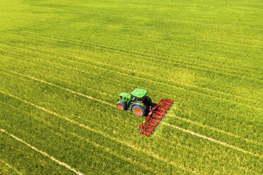 Aerial view of tractor on field, soil loosening, Hochtaunuskreis, Hesse, Germany - AMF07072