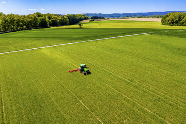 Aerial view of tractor on field, soil loosening, Hochtaunuskreis, Hesse, Germany - AMF07074