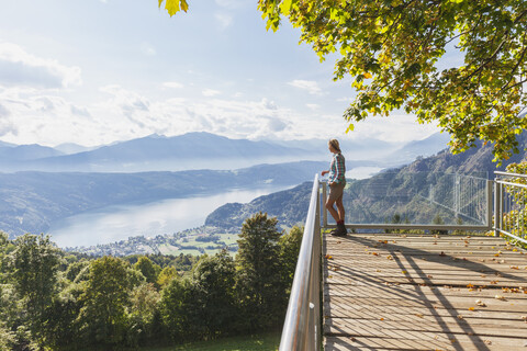 Frau steht auf einem Aussichtspunkt über dem Millstätter See, Kärnten, Österreich, lizenzfreies Stockfoto