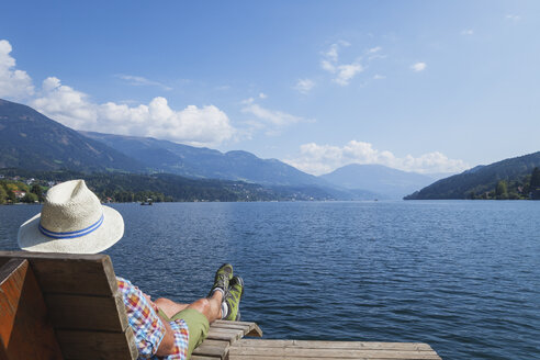 Man resting at lakeshore, Seeboden, Millstatt Lake, Carinthia, Austria - GWF06100