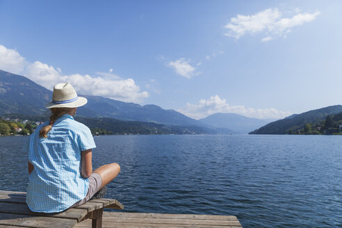 Woman resting at lakeshore, Seeboden, Millstatt Lake, Carinthia, Austria - GWF06101