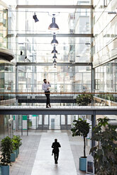 Young businessman standing in lobby at office atrium - MASF12374