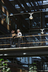 Low angle view of businesswomen communicating at office atrium - MASF12419