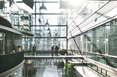 Business people standing in atrium at modern office - MASF12426