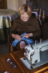 Senior woman working on garment at home - LJF00117
