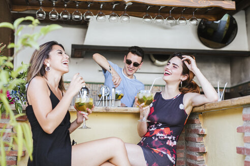 Zwei glückliche Frauen bei einem Drink in einer Bar - LJF00131