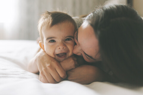 Mutter und Baby kuscheln im Bett zu Hause, lizenzfreies Stockfoto