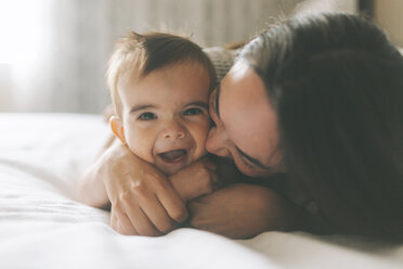 Mutter und Baby kuscheln im Bett zu Hause - CMSF00060