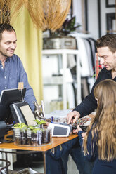 Mädchen tippt Pin-Code an der Kasse im Bekleidungsgeschäft von Vater - MASF12457