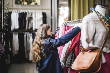 Seitenansicht eines Mädchens beim Einkaufen in einem Bekleidungsgeschäft - MASF12470