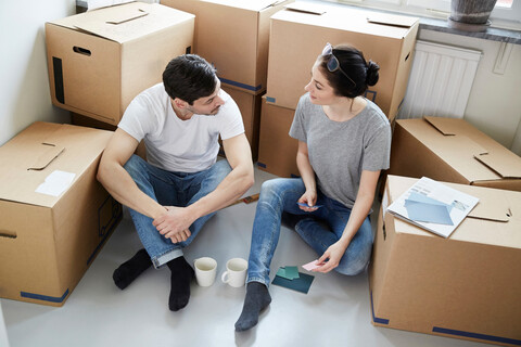 High angle view of couple discussing over color samples during coffee break while moving in new house stock photo