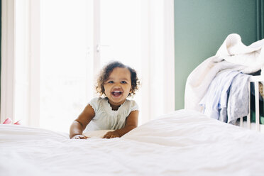 Portrait of cute girl standing by bed at home - MASF12565