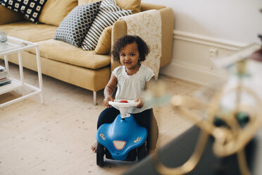 Hohe Winkel Ansicht von Mädchen fahren Spielzeugauto im Wohnzimmer zu Hause - MASF12570