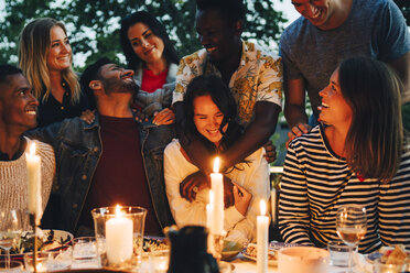 Fröhliche multiethnische Freundinnen und Freunde beim Abendessen - MASF12622