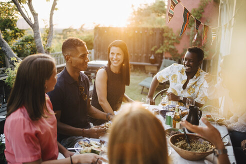 Glückliche Freunde unterhalten sich beim Essen auf einer Dinnerparty - MASF12658