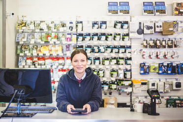 Porträt einer lächelnden reifen Verkäuferin, die in einem Computerladen arbeitet - MASF12717