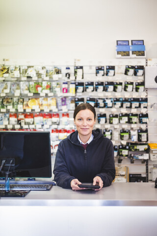 Porträt einer selbstbewussten Verkäuferin in einem Elektronikgeschäft, lizenzfreies Stockfoto