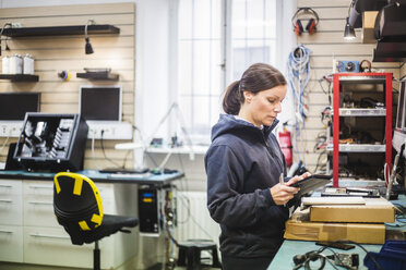 Ingenieur hält digitales Tablet in einem Computerladen - MASF12727