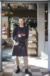 Portrait of smiling mature entrepreneur standing in store - MASF12782