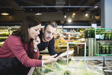 Verkäufer mit digitalem Tablet an einem Marktstand im Supermarkt - MASF12786