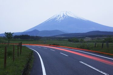 Verschwommene Scheinwerfer auf der Straße vor einem Berg, Japan - MINF11119