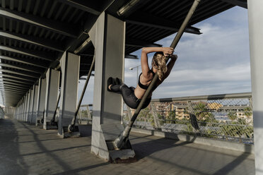Sporty woman working out o a bridge, leaning on bar - ERRF01478