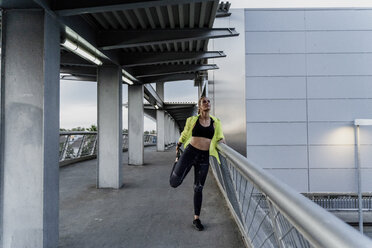 Sportliche Frau beim Dehnen nach dem Training - ERRF01501