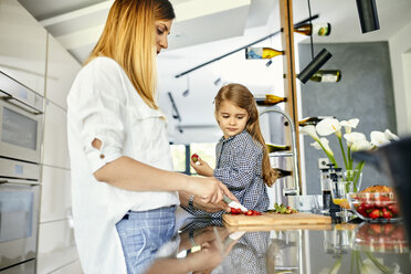 Mutter und Tochter hacken Erdbeeren in einer modernen Küche - ZEDF02340