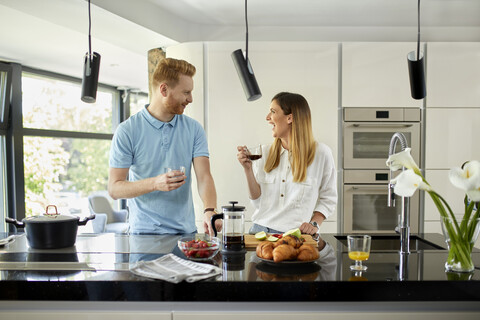 Ehepaar steht in der Küche und bereitet ein gesundes Frühstück vor, schneidet Obst, lizenzfreies Stockfoto