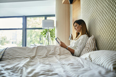 Frau sitzt im Bett und liest ein Buch - ZEDF02394