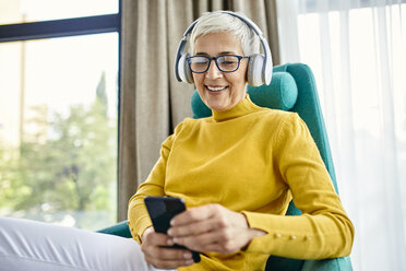 Ältere Frau mit Kopfhörern und Smartphone - ZEDF02409