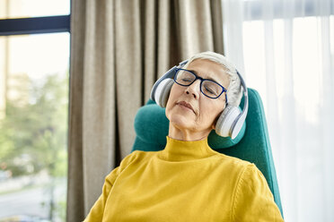 Ältere Frau schlafend im Sessel mit Kopfhörern auf - ZEDF02410