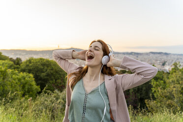 Young redheaded woman with headphones on view point - AFVF03232