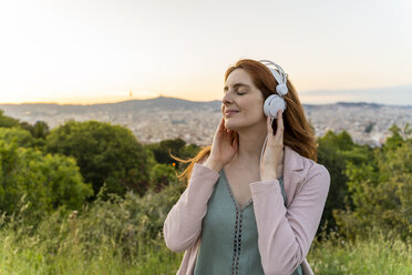 Young redheaded woman with headphones on view point - AFVF03233