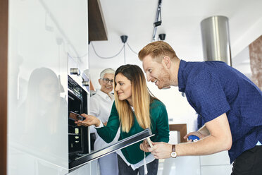 Couple shopping for a new kitchen in showroom - ZEDF02420